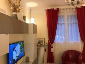 ein Wohnzimmer mit roten Vorhängen und einem TV in der Unterkunft Cosy Home in Paris 15 in Paris