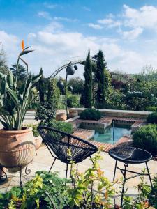 un jardín con 2 sillas y una piscina en Les Grands Jardins Lodge, en Giverny