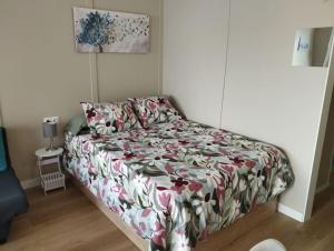een slaapkamer met een bed met een bloemdekbed bij Céntrico estudio en Torremolinos in Torremolinos