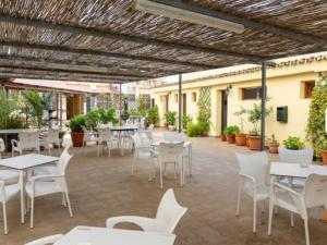 een patio met witte tafels en witte stoelen bij Céntrico estudio en Torremolinos in Torremolinos