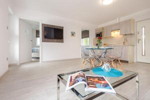 sala de estar con mesa de cristal y cocina en Srebrna Wydma Resort, en Dąbki