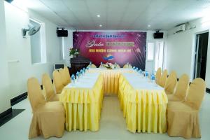un lungo tavolo con sedie in una stanza di SAMMY Hotel - Khách sạn SAMMY a Giáp Vinh Yên