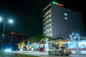 um edifício com luzes de Natal numa rua da cidade à noite em SAMMY Hotel - Khách sạn SAMMY em Giáp Vinh Yên