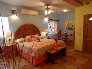 1 dormitorio con 1 cama grande y cabecero de madera en Casa Virgilios B&B, en Nuevo Vallarta 