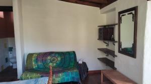 Una habitación con un espejo y una silla en una habitación. en Casita de la Montaña de María, en Tegueste