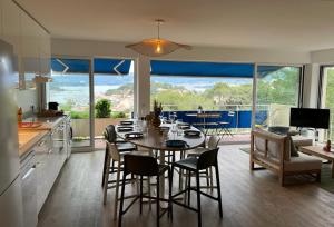 een keuken en eetkamer met een tafel en stoelen bij Saint Mandrier 4 pièces vue exceptionnelle - Location à la semaine uniquement in Saint-Mandrier-sur-Mer