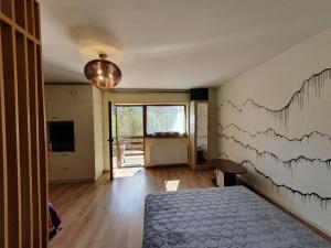 a bedroom with a bed and a wall with a chart at Forest Apartments in Sinaia