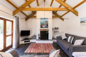 a living room with a couch and a fireplace at Re-imagined Stone Barns in the Country Near the Coast in Padstow