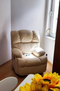 un fauteuil en cuir brun dans une chambre avec une table dans l'établissement Old-timer, à Varna