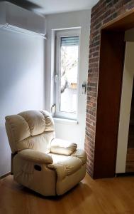 - un fauteuil en cuir dans le salon avec une fenêtre dans l'établissement Old-timer, à Varna