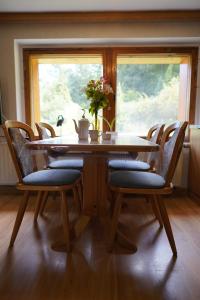 uma mesa de jantar com cadeiras e uma janela em Ferienwohnung Rother 