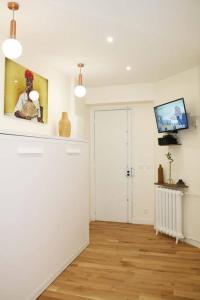 a room with white walls and a wooden floor at Nice studio - 5min Paris Center in Montrouge