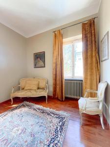 uma sala de estar com um sofá, uma cadeira e uma janela em Villa Tambellini de Fondra em Lucca