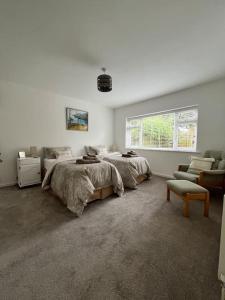 a bedroom with two beds and a chair and a window at 4 bed countryside home near Solihull & NEC - Sleeps 8 in Solihull