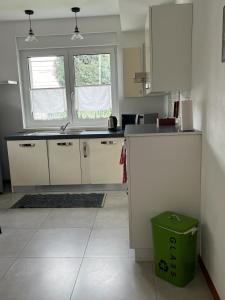 uma cozinha com armários brancos e uma lata de lixo verde em CasaNobile "Il Grano" em Merate
