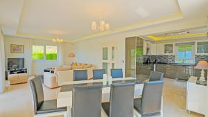 a dining room and living room with a table and chairs at Villa Bianca in Fethiye