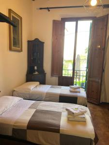 2 Betten in einem Hotelzimmer mit Fenster in der Unterkunft Casa Spadi in Florenz