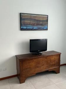 uma televisão de ecrã plano em cima de uma mesa de madeira em CasaNobile "Il Grano" em Merate
