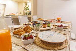 a table topped with plates of food and fruit at Montellinos Suite Tortora in SantʼAntìoco