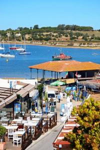 a dock with tables and chairs next to a body of water at Alvor Apartments - Center and Beach in Alvor