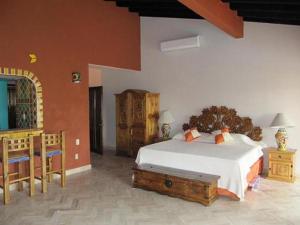1 dormitorio con 1 cama, mesa y sillas en Casa Virgilios B&B, en Nuevo Vallarta 