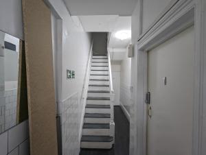 a staircase in a hallway with white walls and white tiles at Inner-City Apartments - Basic Amenites in Cardiff