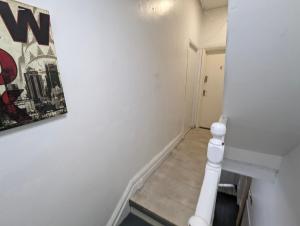 a hallway with white walls and a picture on the wall at Inner-City Apartments - Basic Amenites in Cardiff
