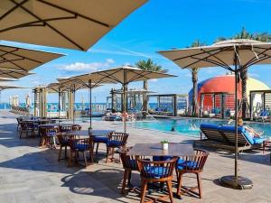 a pool with tables and chairs and umbrellas at Amazing Ocean Views At Hyde Resort By rent4us in Hollywood