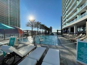 a swimming pool with lounge chairs and palm trees in a building at Amazing Ocean Views At Hyde Resort By rent4us in Hollywood