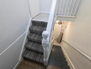a spiralling staircase with a white hand rail in a stair case at Inner-City Apartments - Basic Amenites in Cardiff