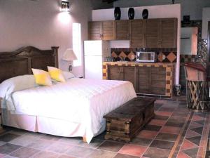 a bedroom with a large bed and a kitchen at Casa Virgilios B&B in Nuevo Vallarta