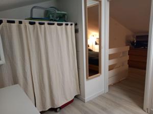 a bedroom with a shower curtain and a mirror at Le duplex panoramic sur Mer et Lido in Sète