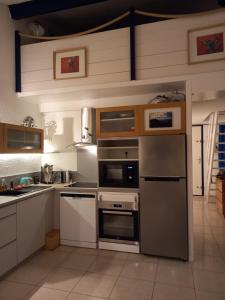 a kitchen with stainless steel appliances and wooden cabinets at Le duplex panoramic sur Mer et Lido in Sète
