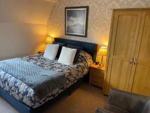 a bedroom with a bed with two pillows and a chair at Park View Apartment & Rooms in Scarborough