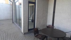 a table and chairs on a patio with a glass door at the holiday house in Klaipėda