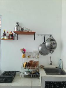 una cocina con fregadero y una estantería con pan en Rumah Pemandangan Pegunungan & sawah, en Banyumas
