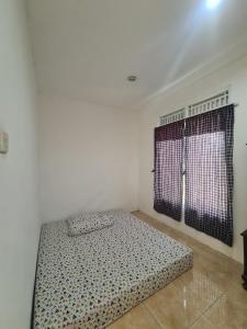 a bed in a room with a large window at Rumah Pemandangan Pegunungan & sawah in Banyumas