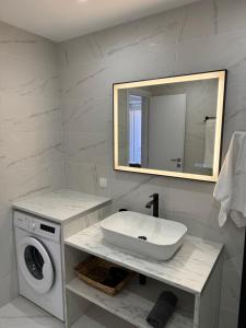 a bathroom with a sink and a washing machine at Central Suites Aegina 4 in Aegina Town +53 photos