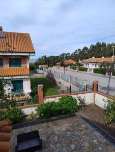 uma casa com uma cerca ao lado de uma rua em Dúplex Somo Beach em Somo