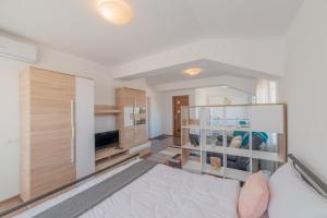 een woonkamer met een bed en een televisie bij Casa Zorilor Cluj in Cluj-Napoca