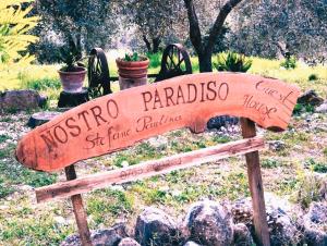 a sign for a garden with a wooden surfboard at Nostro Paradiso in Monteleone Sabino
