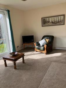 a living room with a couch and a coffee table at Dunholm Cottage in Skelmorlie