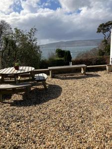 a picnic table and bench with a view of the ocean at Dunholm Cottage in Skelmorlie