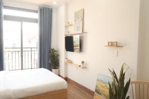 a bedroom with a bed and a window at Kōzē Mini Apartment in Da Lat