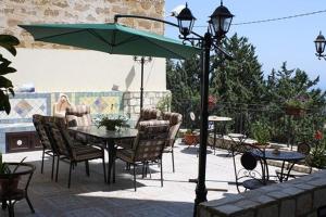 a patio with a table and chairs and an umbrella at Bed and Breakfast Don Angelo Miramare in Realmonte