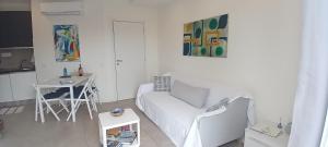 a white living room with a white couch and a table at Mirasole Holiday House in Leggiuno