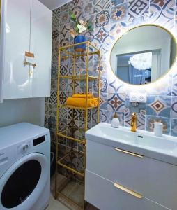 a bathroom with a sink and a mirror and a washing machine at Au Petit Trianon Bleu in Versailles