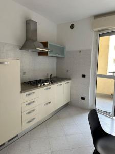 een keuken met witte kasten en een fornuis bij Cozy suite with terrace in Castellanza