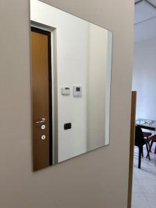 een spiegel aan de zijkant van een muur met een deur bij Cozy suite with terrace in Castellanza