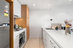 a kitchen with white counters and a stove top oven at Sea View, Gym & Pool, 2 bedrooms 2 bathrooms in Melbourne +9 photos